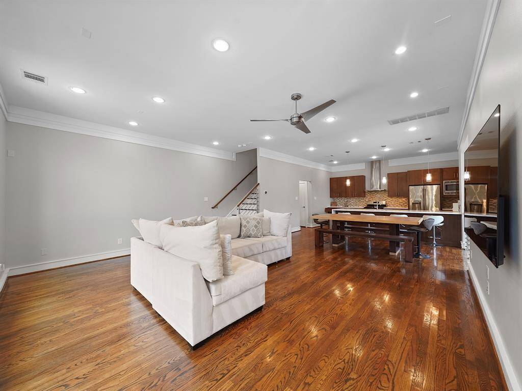 Step into a world of warmth and light. This home boasts a beautiful, open main living area where rich wood flooring creates a stunning contrast against the bright and airy walls. A perfect blend of comfort and style awaits.