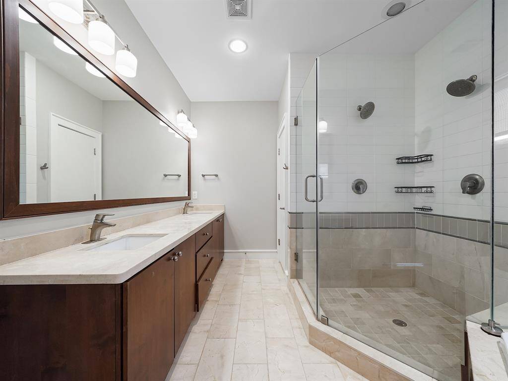 Indulge in the luxurious primary ensuite, a true sanctuary of relaxation. Unwind in the corner jetted tub or refresh in the oversized shower featuring dual showerheads. Dual sinks provide ample space and convenience. This spa-like bathroom offers the perfect escape within your own home, promising comfort and tranquility.