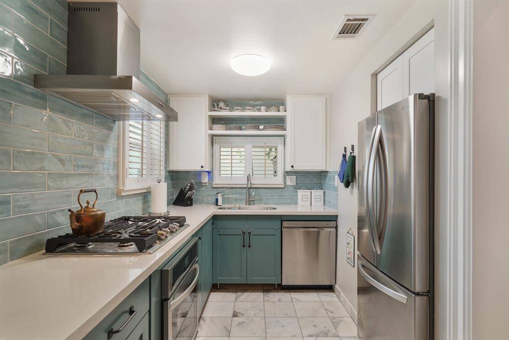 Although compact, the kitchen is efficient, with ample counter space and natural light from a window above the sink.
