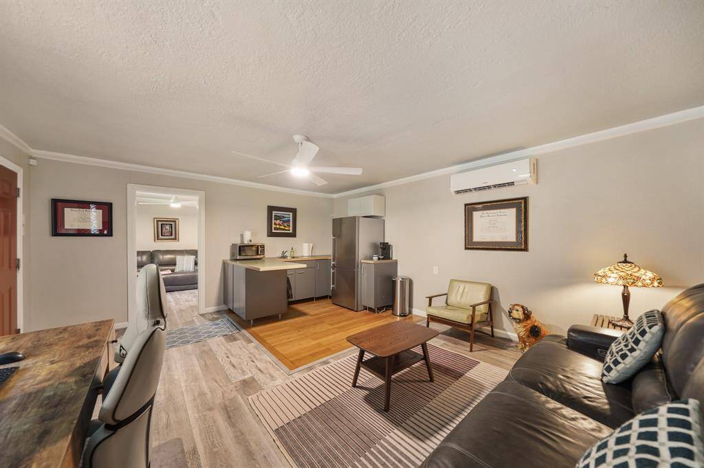 Another angle of the cozy living space features a modern open layout with a compact kitchenette, comfortable seating, and a small work area.