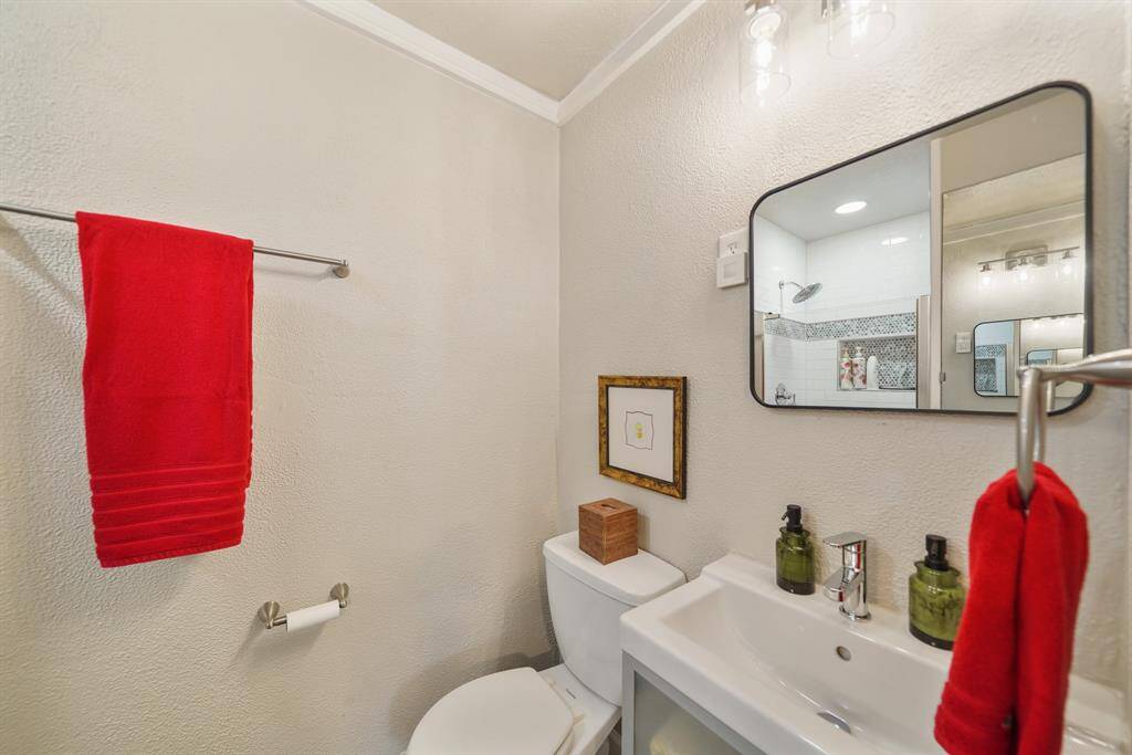 This is a compact, modern bathroom featuring a large mirror and contemporary lighting to enhance the space, creating a bright and welcoming feel.