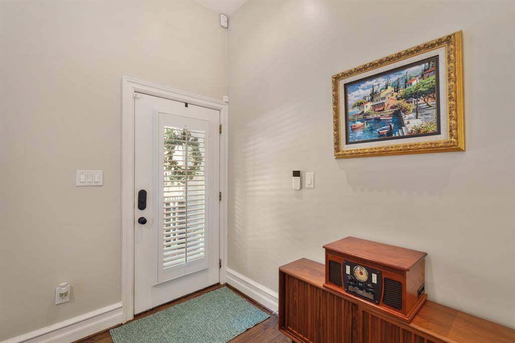 This bright entryway features a door with glass inserts that allows natural light, and a wooden console adds warmth. Perfect for welcoming guests.
