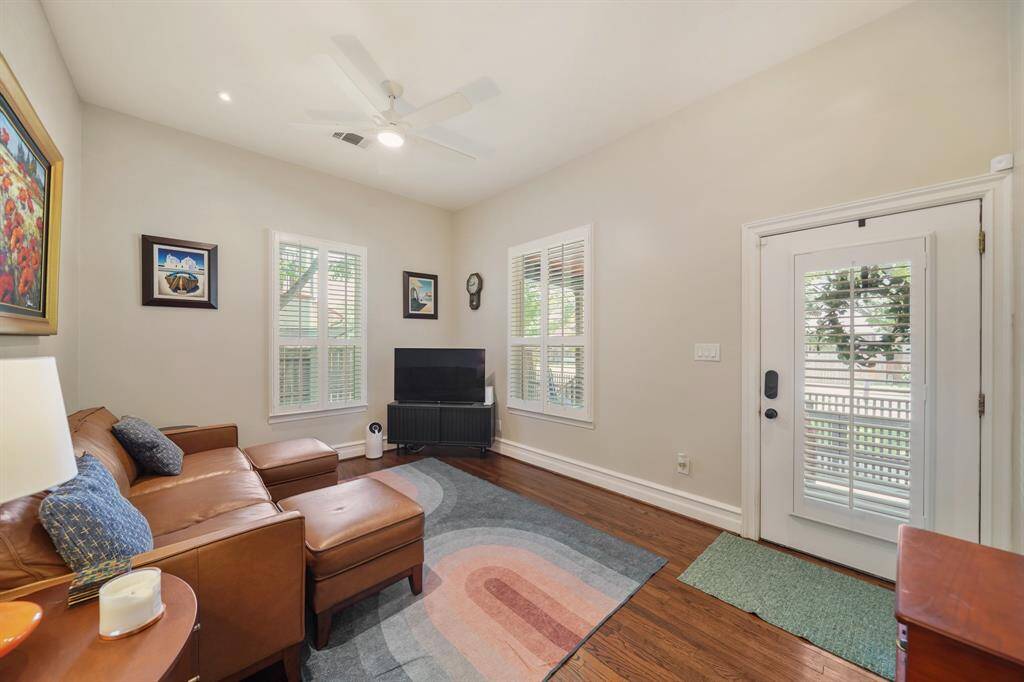 Cozy living room with neutral walls, hardwood floors, and ample natural light.