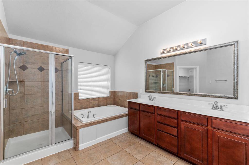 Primary bathroom - features a spacious walk-in closet, a convenient linen closet, and a frameless glass shower enclosure for a clean and modern aesthetic
