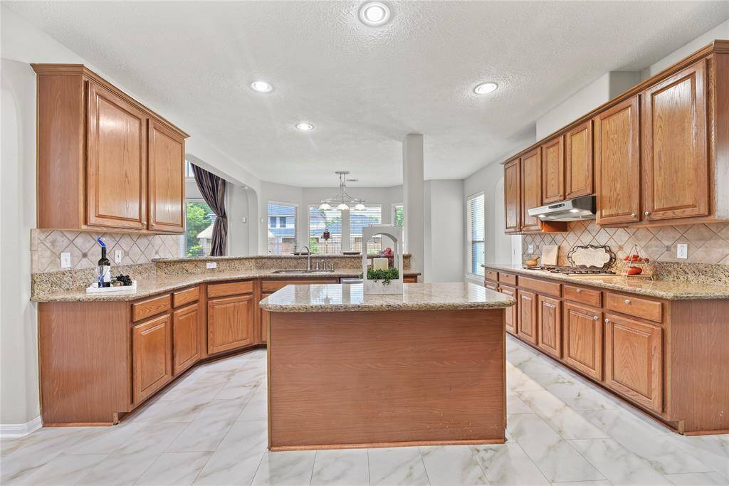 Large island, granite countertops, tile backsplash, stainless appliances, gas cooktop and tons of storage!