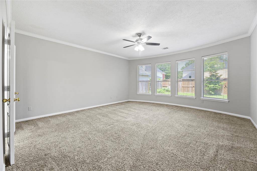 The primary bedroom is spacious with plush carpet, ceiling fan and an en-suite bathroom.