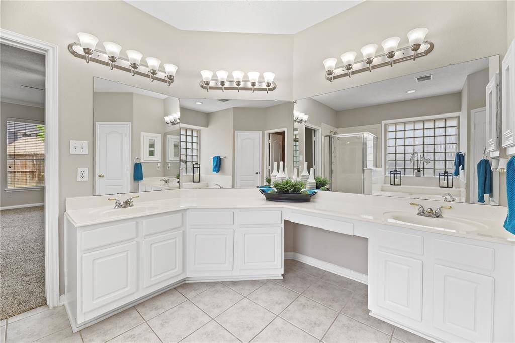Primary bathroom is complete with a dual sink vanity, jetted tub, separate shower and walk-in closet.