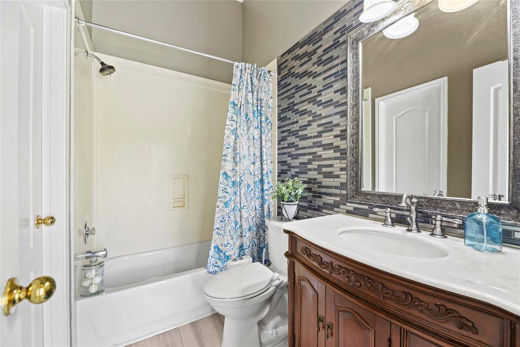 Guest suite bathroom with an elegant vanity and tub/shower combination.