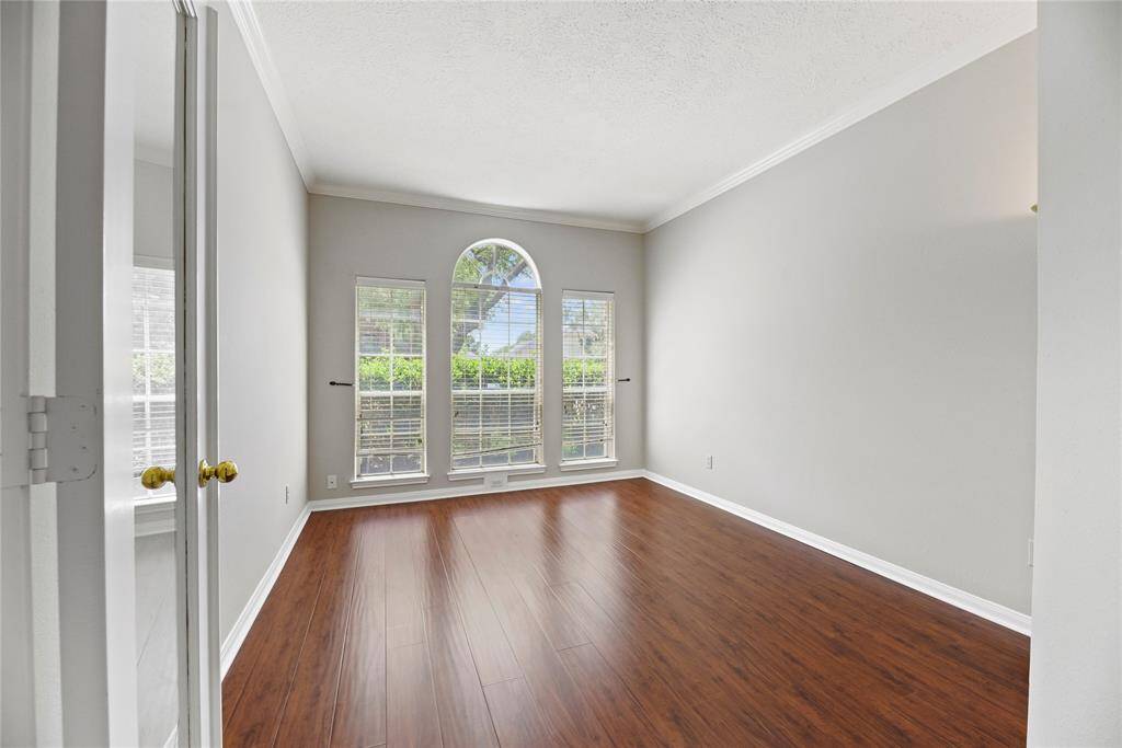 Private home office with crown molding and laminate flooring.