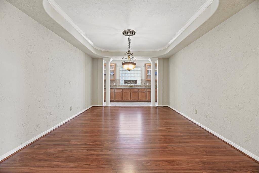 Formal dining room with a tray ceiling, crown molding and elegant chandelier.