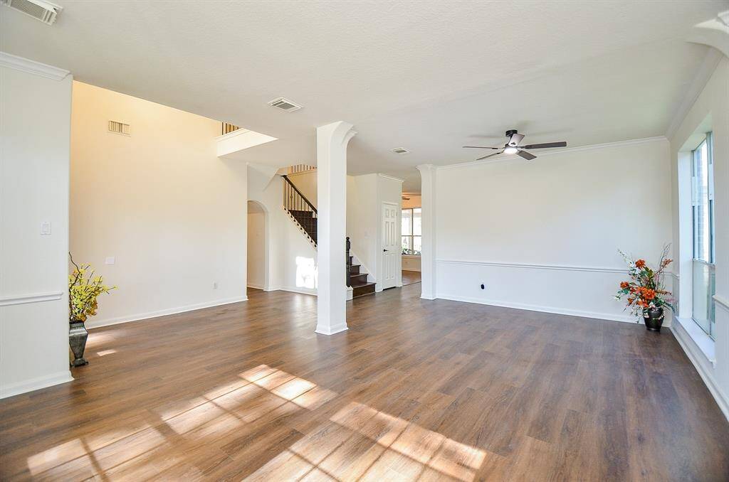Gleaming LVP flooring in the formal living and dining area. New ceiling fan and light in the formal living area