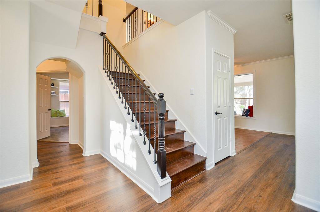 Wood stairwell leads to 4 bedrooms upstairs