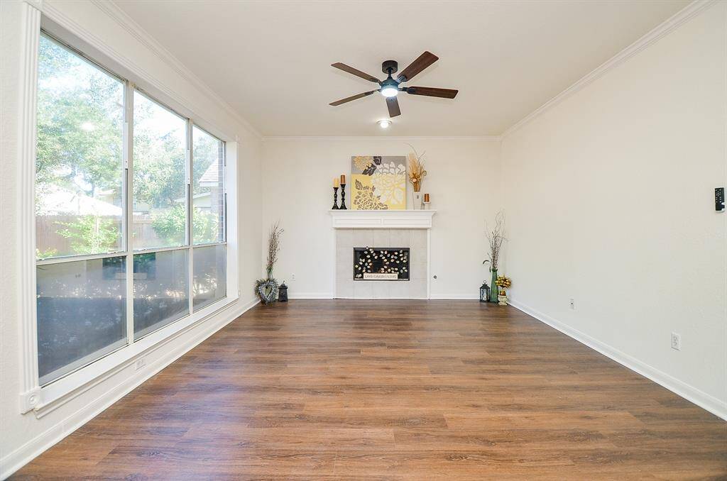 Family room has  fireplace and new gleaming LVP flooring and new ceiling fan with light