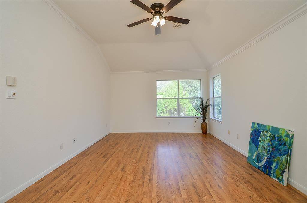 Spacious primary bedroom with crown molding will fit all your big bedroom furniture