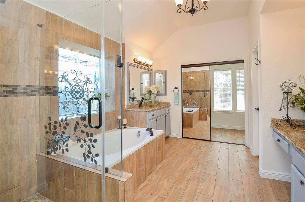 Renovated primary bathroom has a jetted tub and a big walk in shower