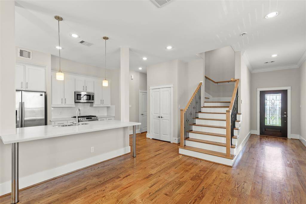 standing mid living room looking back to front foyer and steps to upper floors