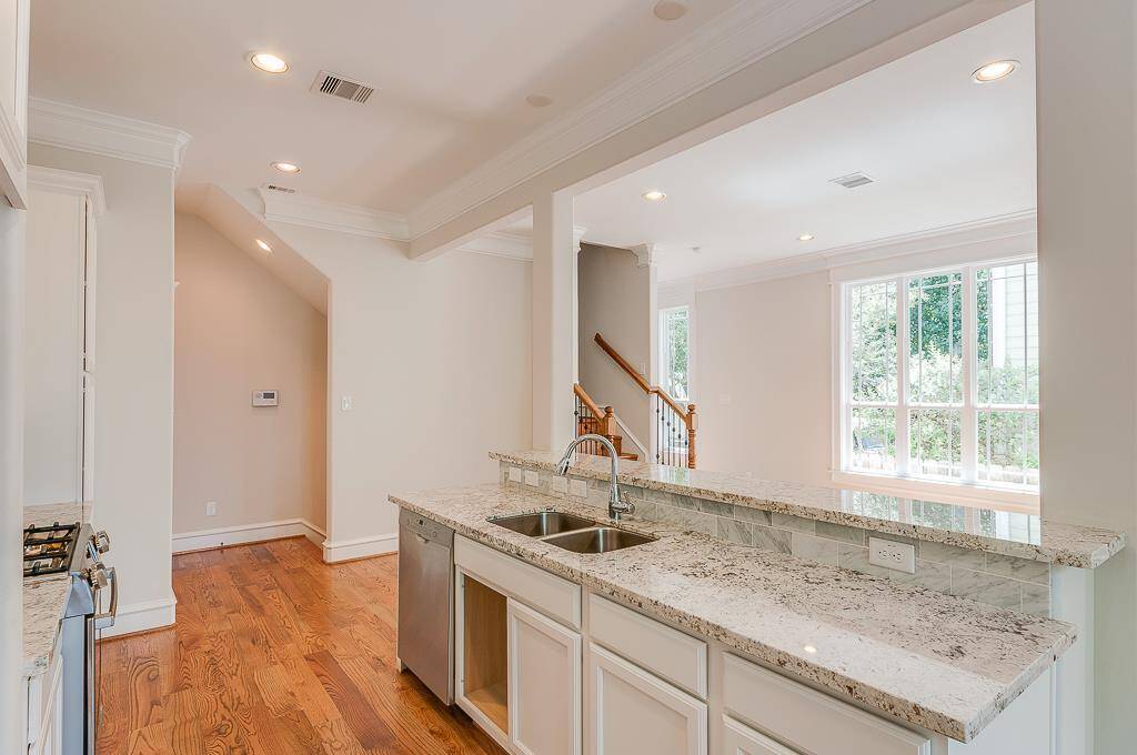 looking across oversized island/breakfast bar, notice the big windows and natural light