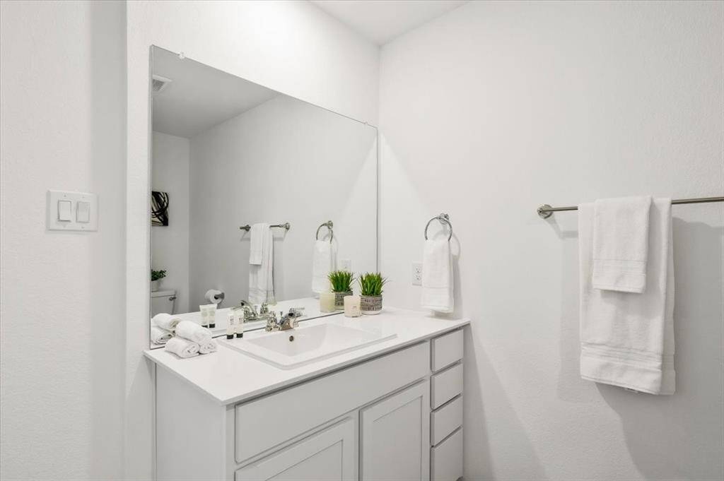 This angle highlights the white vanity with a towel holder, showcasing thoughtful details that reflect the owners' care and attention in maintaining their home.