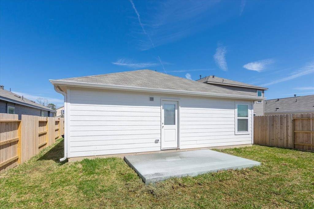 A great view of the back of the house and new concrete patio—just set up your table and chairs to enjoy your morning coffee. The back door leads directly to the kitchen, creating a natural flow between indoor and outdoor living.