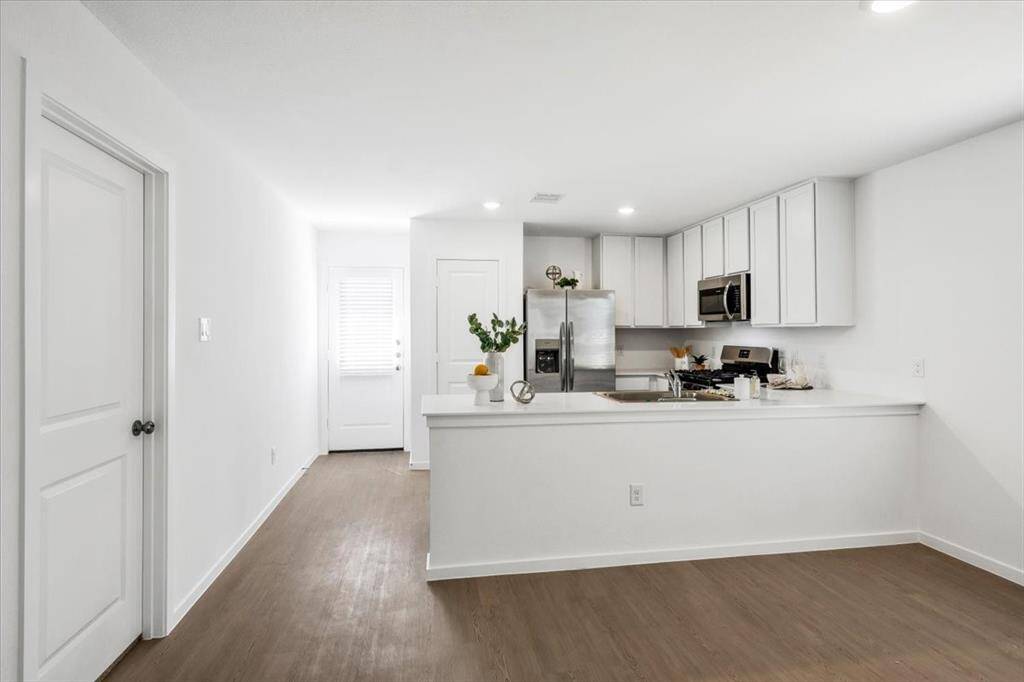 Bright and airy kitchen with direct patio access, seamlessly blending indoor and outdoor living. Just beyond the door, a newly added concrete patio offers the perfect space to enjoy the private backyard.