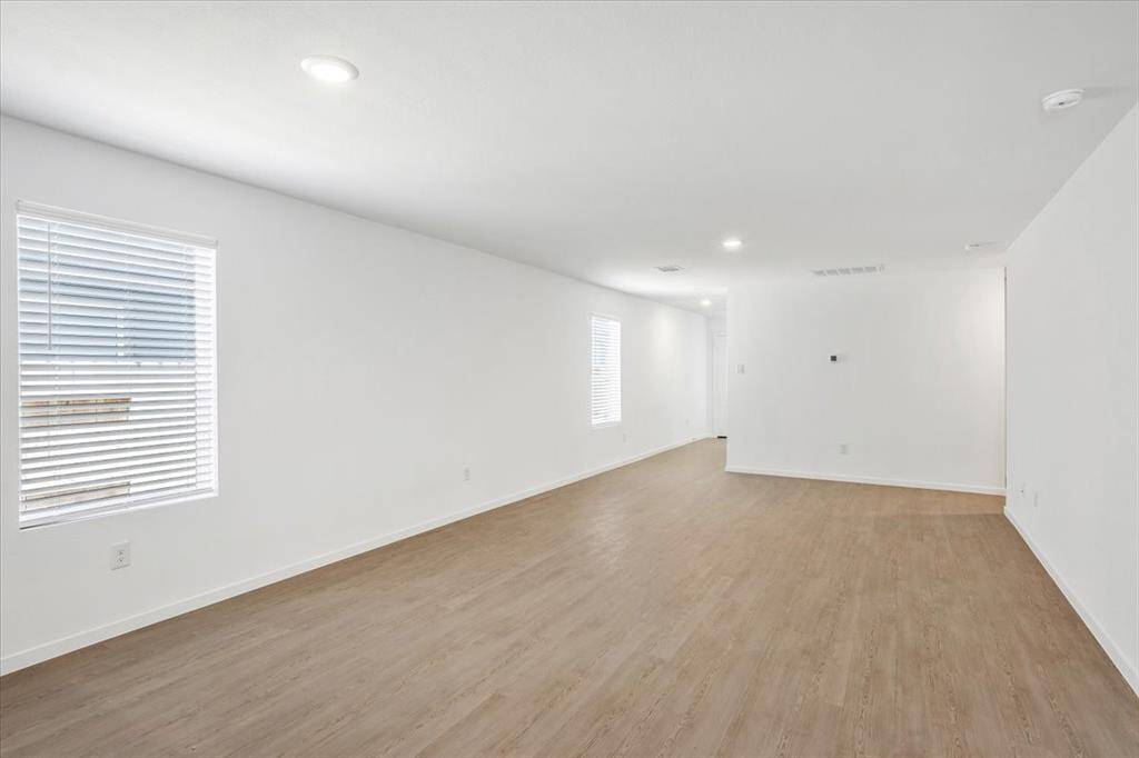 This view highlights the additional window, filling the space with natural light, and the hallway leading to the front entry. The thoughtful layout provides a sense of privacy, creating a subtle separation between the main entry and the living area.