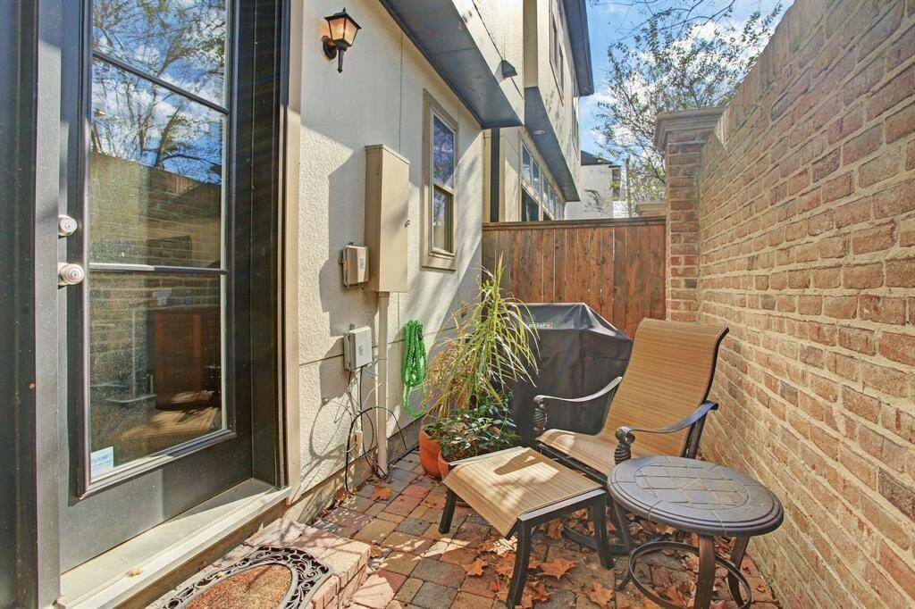 This cozy outdoor patio features a brick-paved area. It's enclosed with a charming brick wall and wooden fence, perfect for private relaxation or small gatherings.