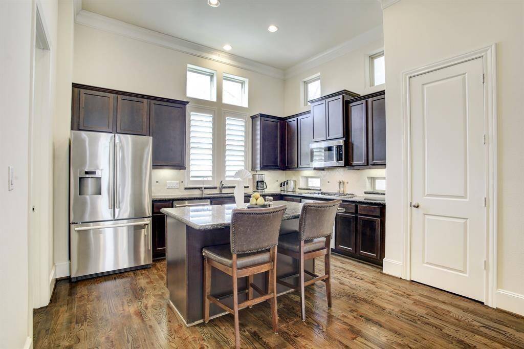 The kitchen includes modern stainless steel appliances and a central island with seating. Refrigerator Included in rent price.
