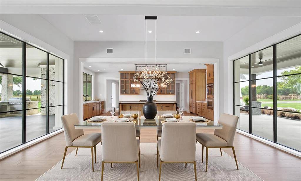 The dining area sits as the centerpiece in this open concept design with floor to ceiling windows that give the feeling of an open air dining experience.  Plenty of light that both warms the space adds a nice cozy feeling.