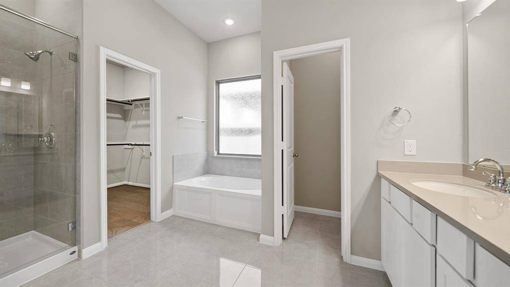 The Peaceful Primary Bath Oasis features terrific tile flooring, dual sinks, glass encased shower with tile surround, soaking tub, and direct access to the wonderful walk in closet.