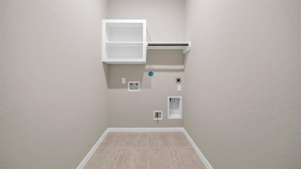 In house laundry room offers tile flooring, hanging bar and storage above, making laundry day a breeze!