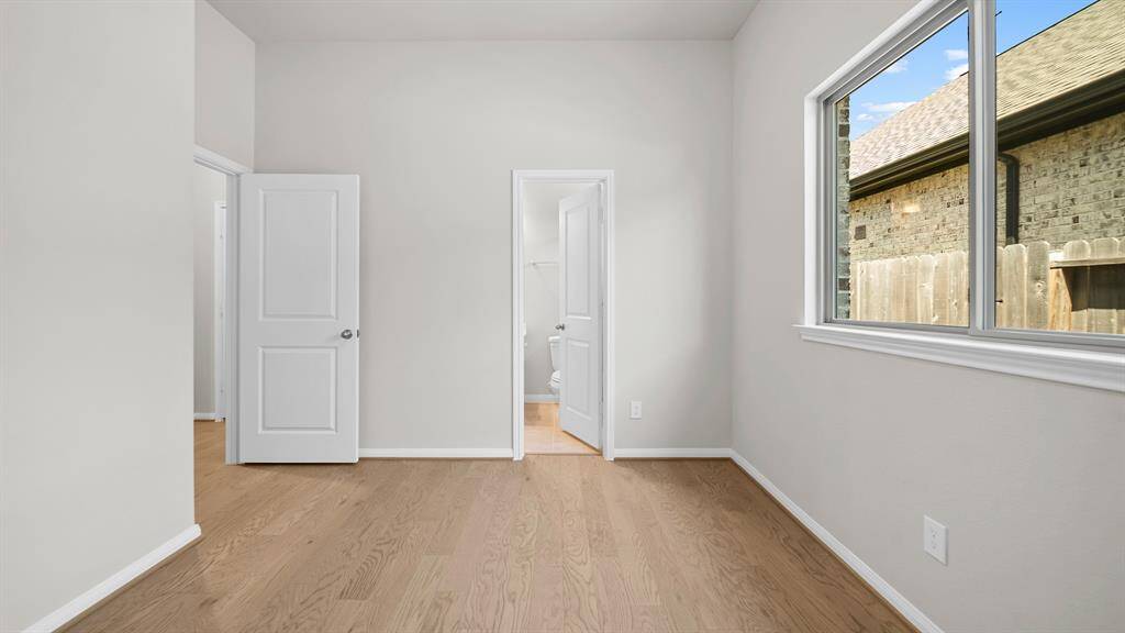 This Secondary Bedroom located at the front of the home boasts tall ceilings and an en suite bath, great for guests!