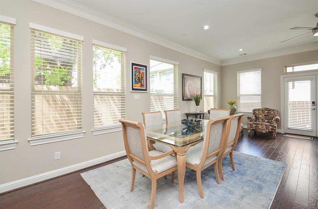 Dinner with a view and a touch of elegance. The double crown molding, transom windows, and rich wood floors elevate this bright dining space—perfect for casual weeknights or lively weekend dinners with friends and family.