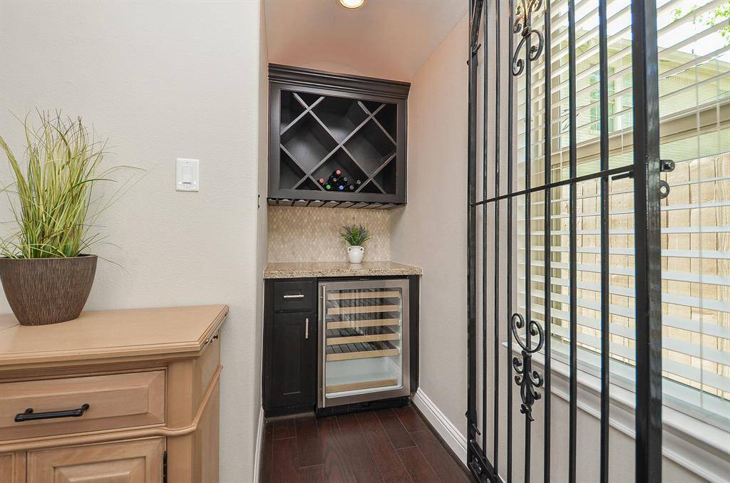 The custom wine nook, complete with a built-in wine fridge, rich cabinetry, and warm natural light.