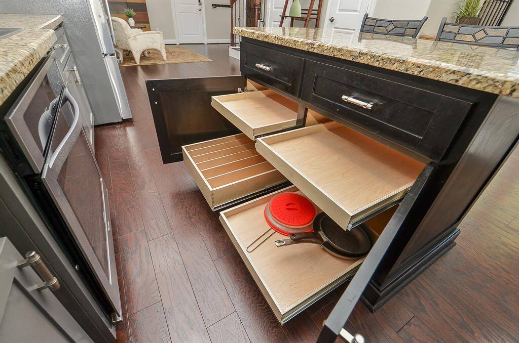 Because digging through cabinets is so last year. These ShelfGenie pull-out drawers, added in 2023, make staying organized effortless—everything’s in reach, nothing’s lost in the back. Plus, that contrast between the rich cabinetry and warm floors? Chef’s kiss.