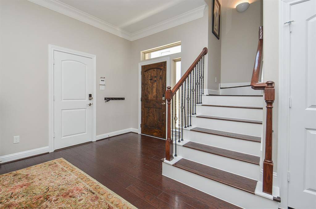 Let’s head upstairs—your next favorite spaces are waiting. The elegant hardwood floors, wrought iron balusters, and rich wood handrails make even the journey between floors feel like something special.