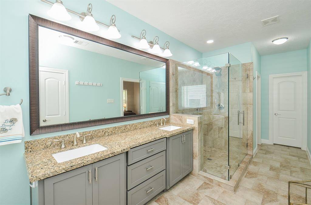 Your morning routine just got an upgrade. With double sinks, modern gray cabinetry, and an oversized glass-enclosed shower, this space is built for both calm and convenience. Bright, airy, and thoughtfully updated—it’s a bathroom that actually makes you want to take your time.