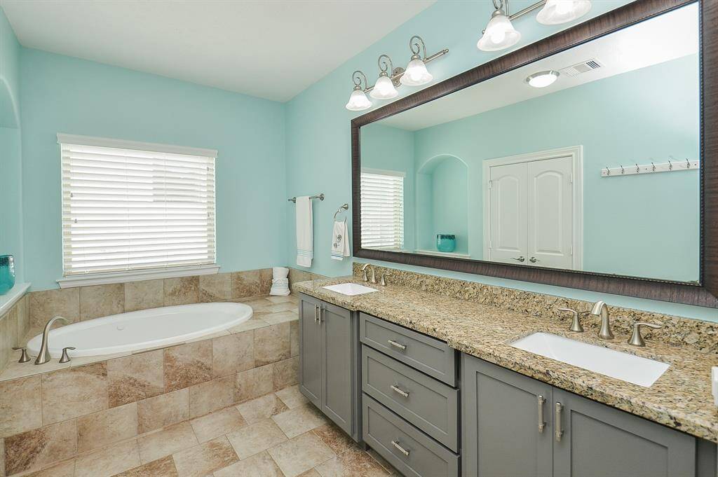 Two sinks, zero stress. With granite counters, stylish gray cabinetry, and plenty of space to share, this setup makes busy mornings feel a little more calm—and a lot more beautiful.