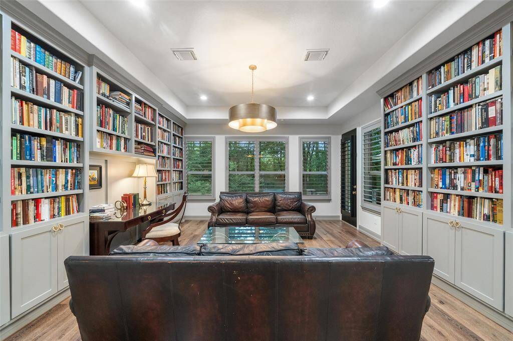 The library is breathtaking with views of the backyard and patio access. There is room for a desk and furniture. Custom lighting and custom book shelves and cabinets with updated hardware.