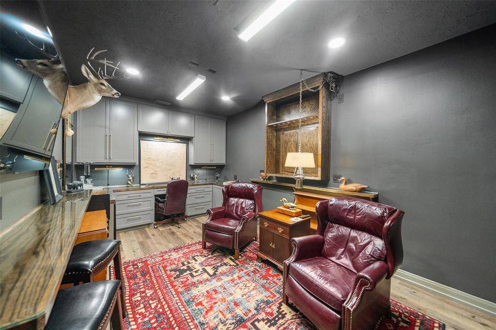 The man cave is a fun room where the 3rd car garage was converted. Room for 2 full safes (not pictured) and it is appointed with custom cabinets, new hardware, floating bar and beverage fridge.