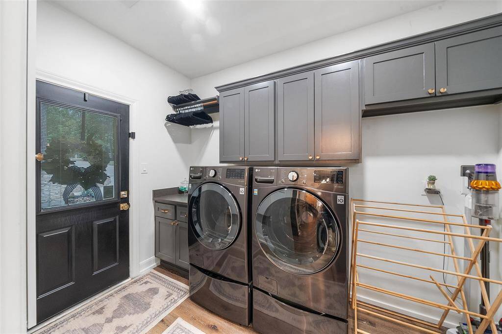 Laundry room with Iron-A-Way 52" center, updated cabinets and hardware and access to the driveway.