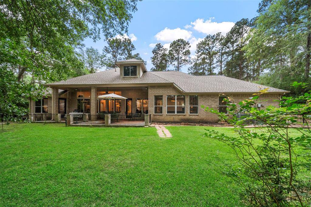 Back of home with an expansive covered patio and room for a pool.