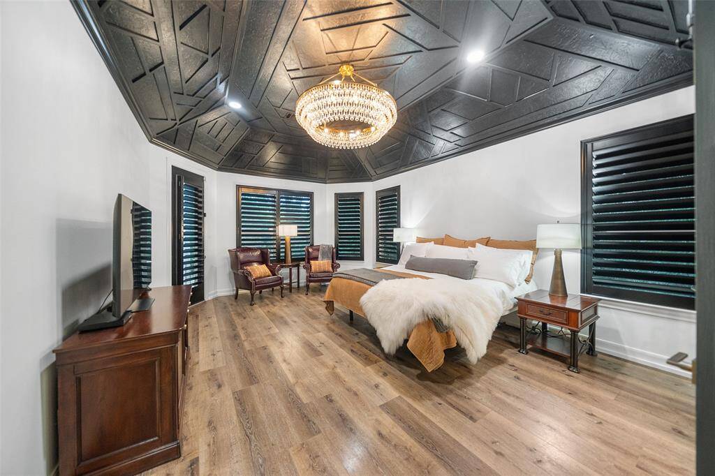 The primary bedroom is like no other with custom 5" blinds, custom ceiling, SPC Flooring, high end chandelier and sitting area. Easy access to the back patio to enjoy your morning coffee!