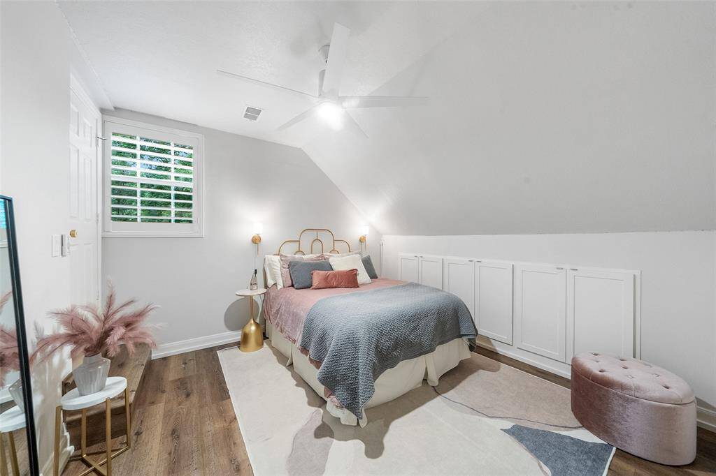 Guest bedroom located on the second level. There is a wall of storage and a walk-in closet and access to the attic.