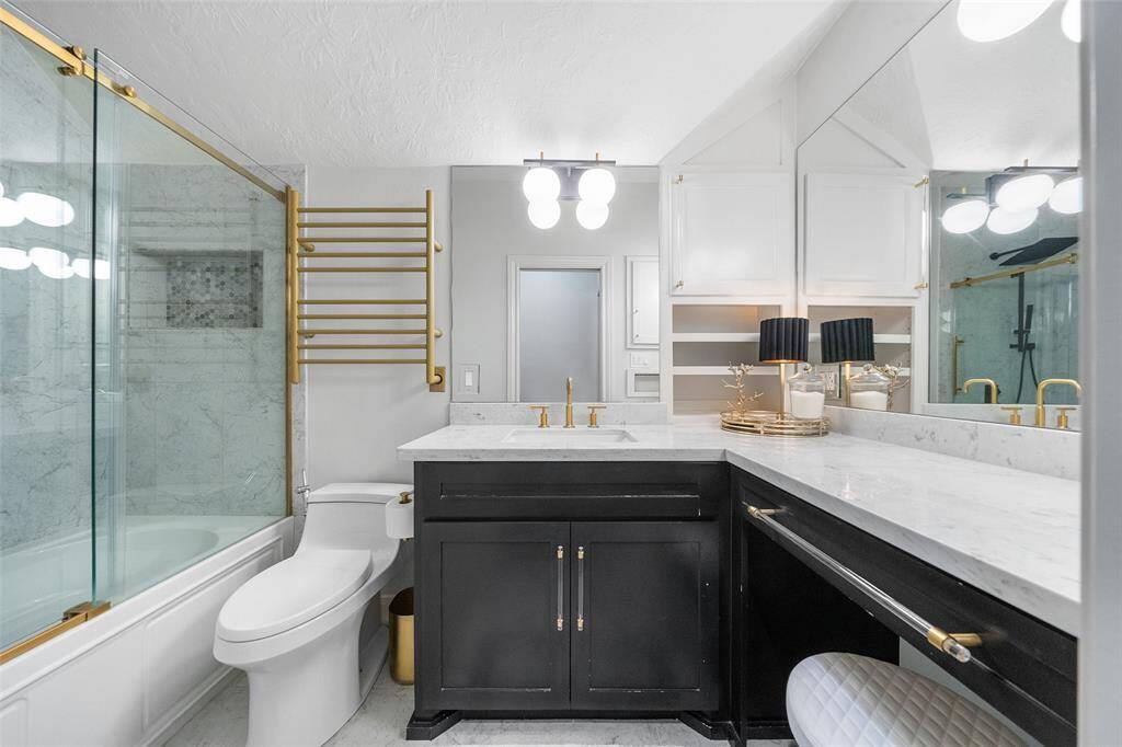 Full bathroom located upstairs with sliding glass doors, towel warmer, new hardware and fixtures. New toilet and vanity area.