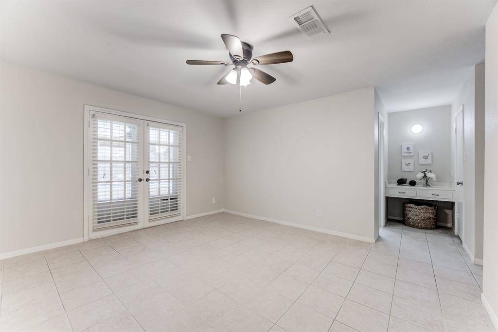 This generously sized primary bedroom offers a comfortable and stylish retreat with durable tiled floors. Elegant French doors provide a beautiful transition and direct access to your private outdoor oasis, perfect for enjoying fresh air and relaxation.