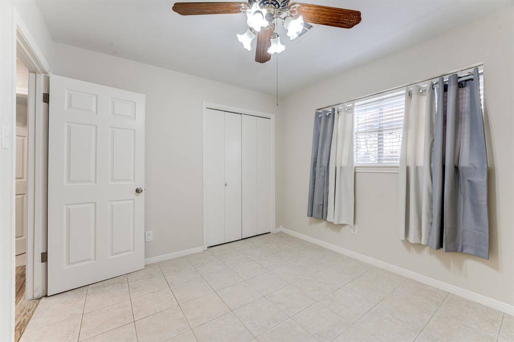 Cozy secondary bedroom with ceiling fan and large window.