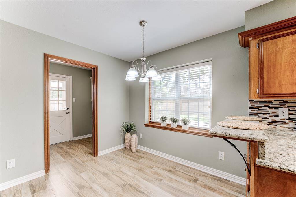 Start your day right in this charming breakfast area featuring solid wood accents and abundant natural light from a large window.
