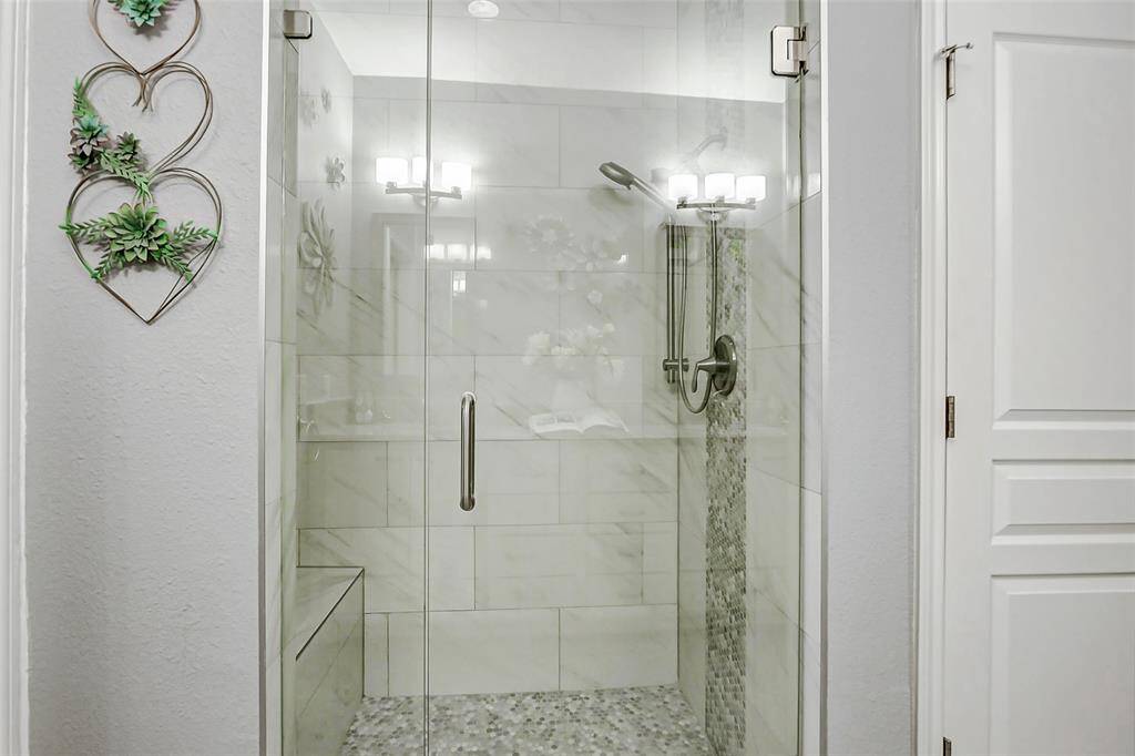 Incredible double head shower with custom tile work in the primary bathroom.  Complete with linen closet to the right.
