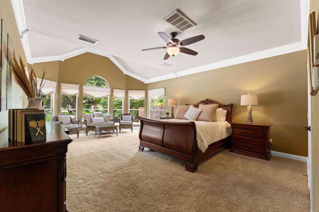 The primary master bedroom is enormous and has a large sitting area with a wall of windows looking out to the pool and lake.