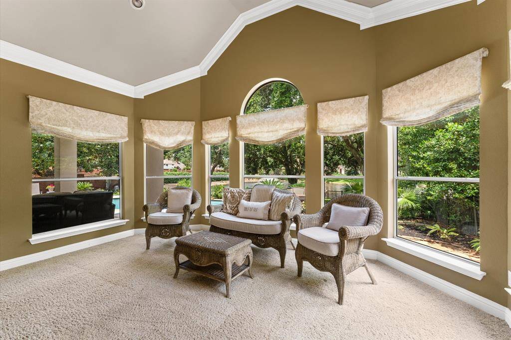 The sitting area. The primary bedroom has crown molding and recessed lighting.
